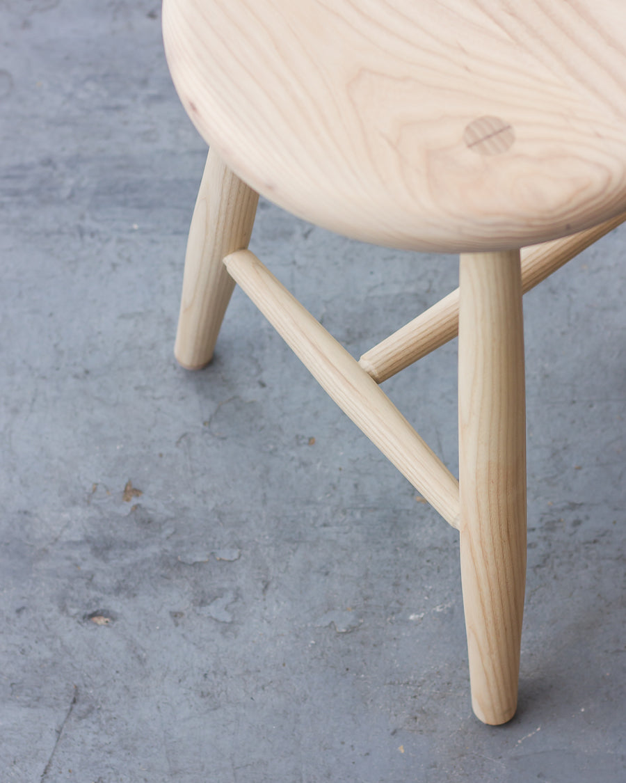 Wooden stool on a gray concrete floor
