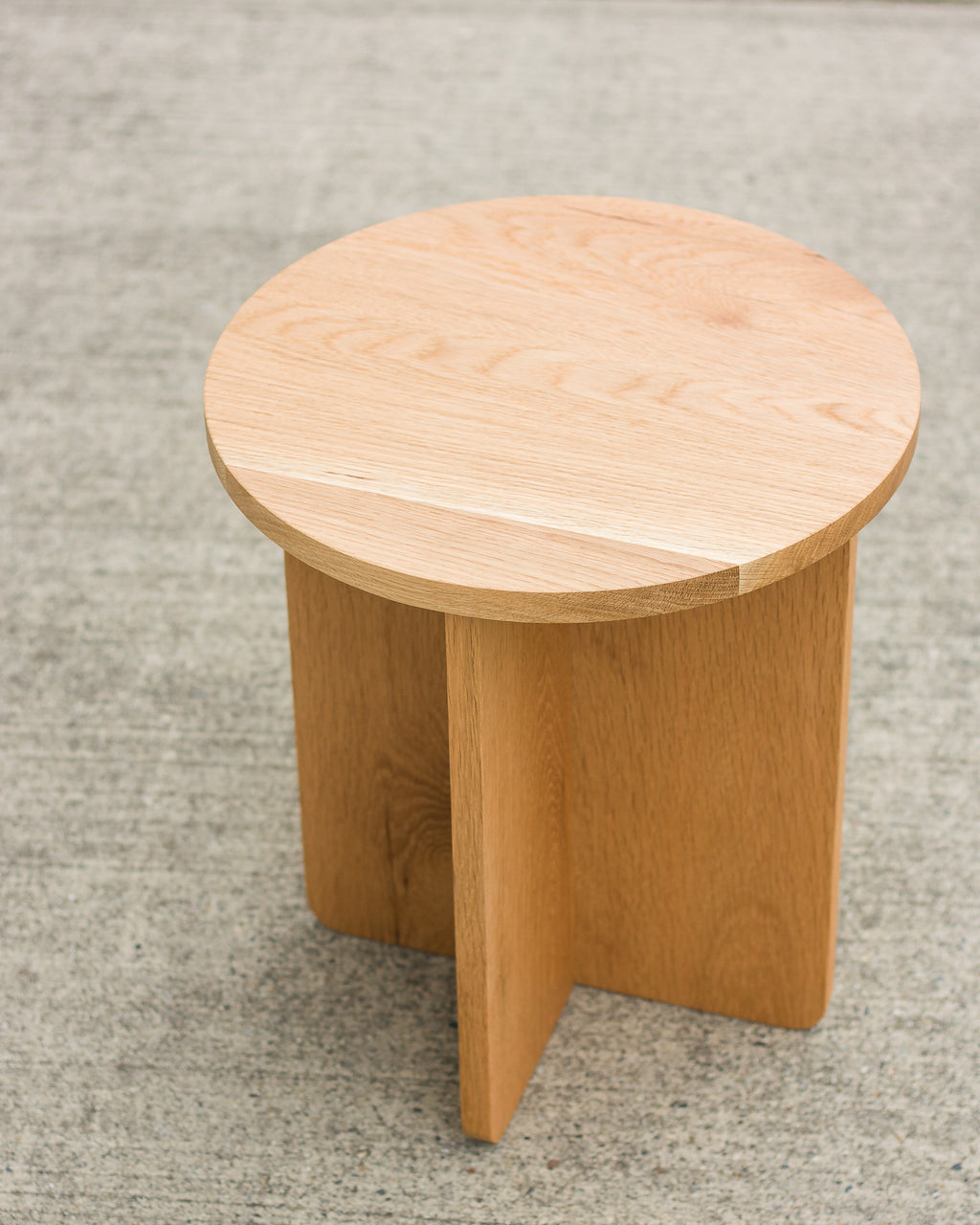 Wooden stool on a textured gray floor