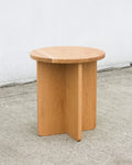 Wooden side table on a concrete floor with a white wall background