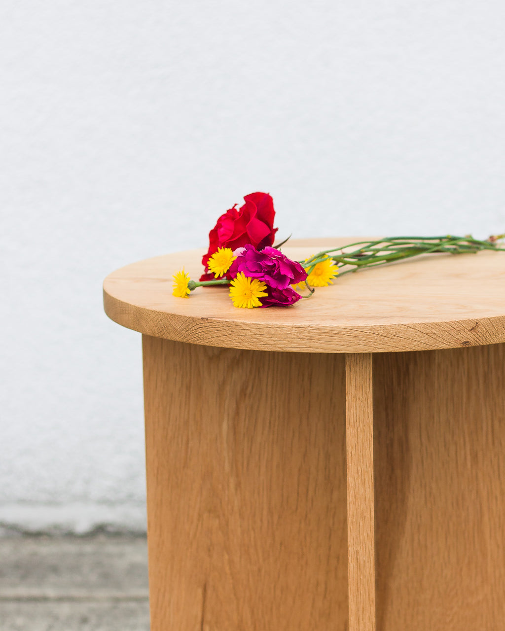 Wooden table with colorful flowers on a light background