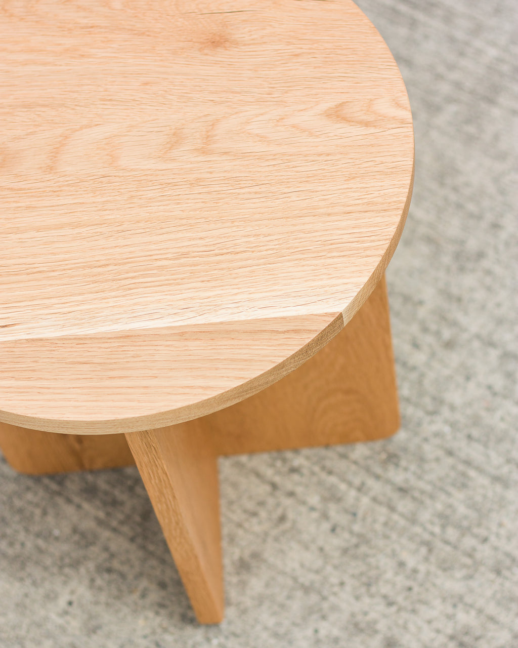 Close-up of a wooden side table on a carpeted floor