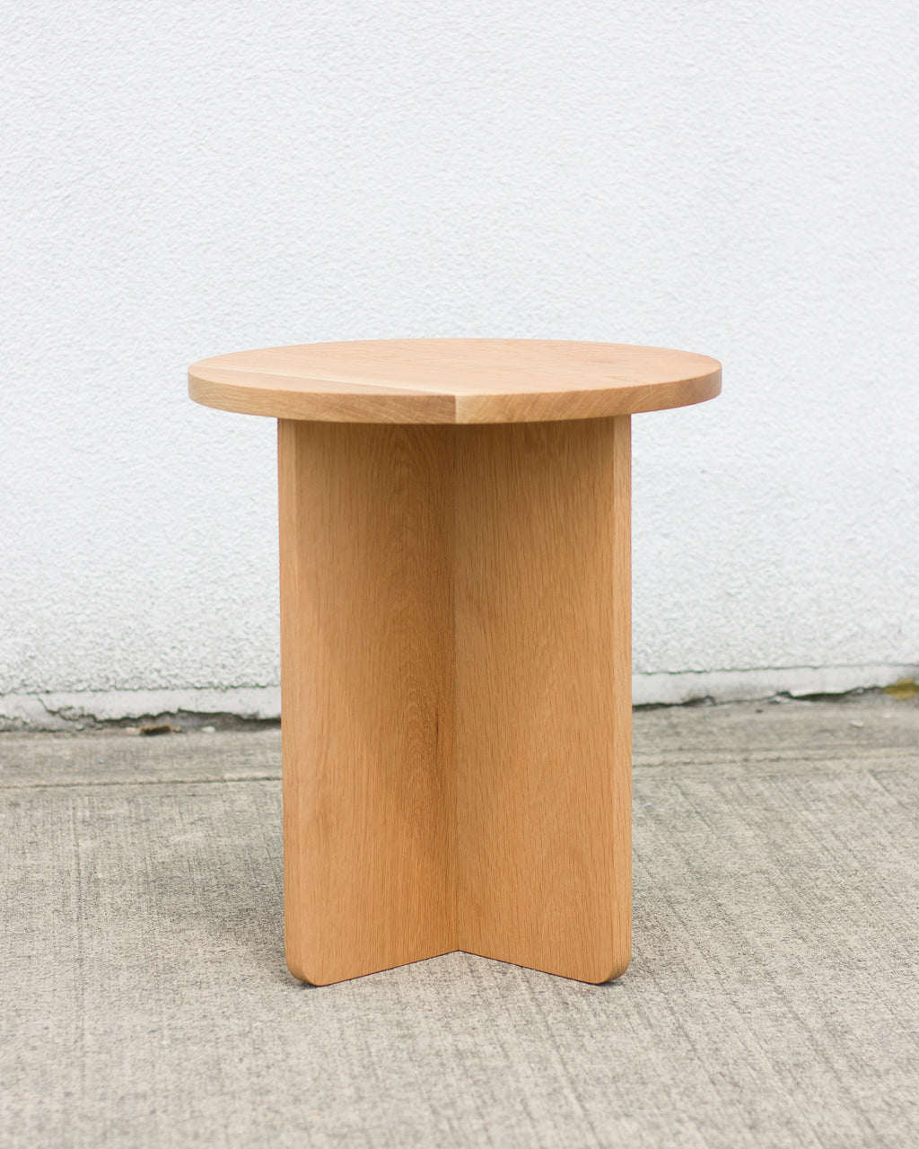 Wooden side table against a white wall