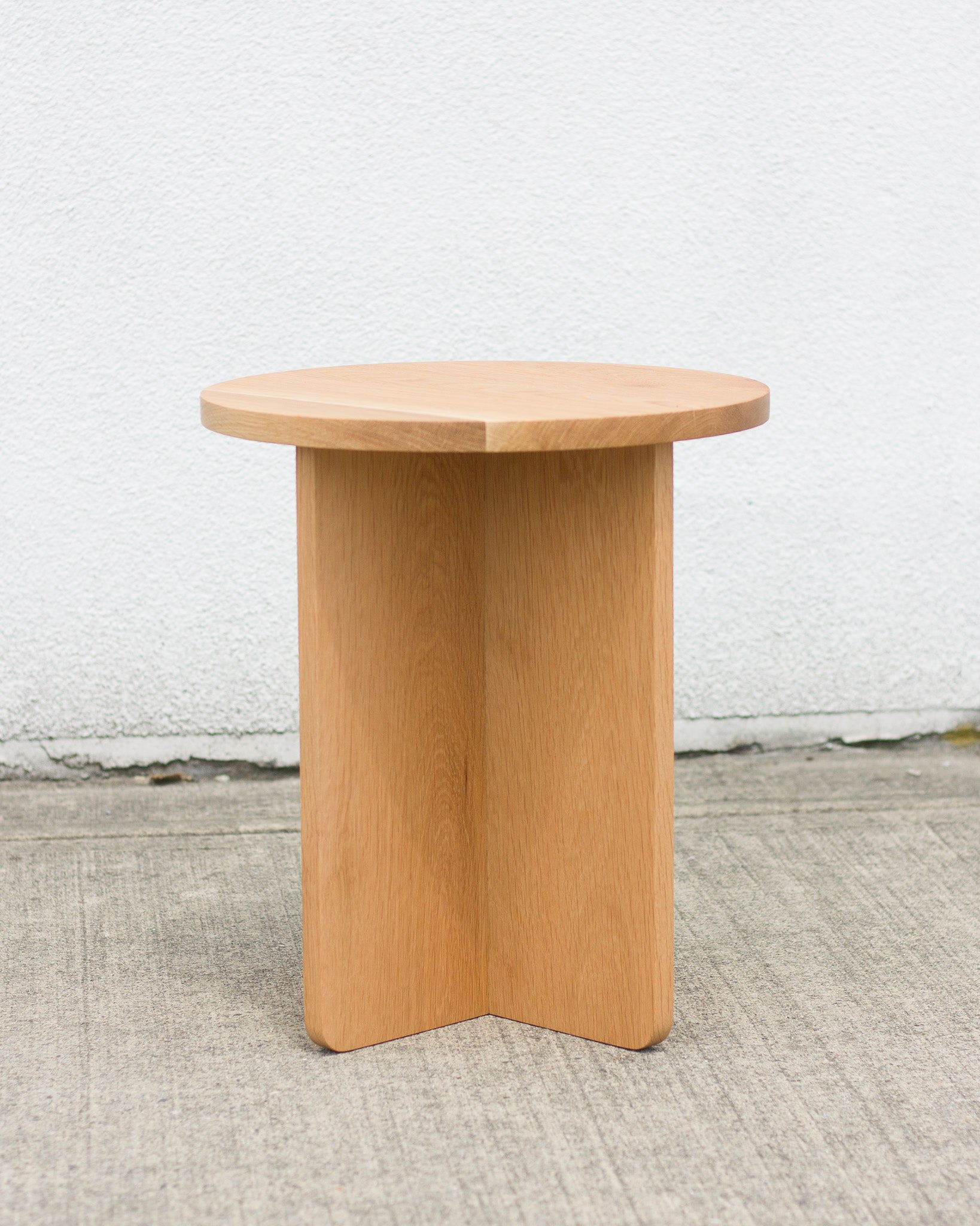 Wooden side table against a white wall