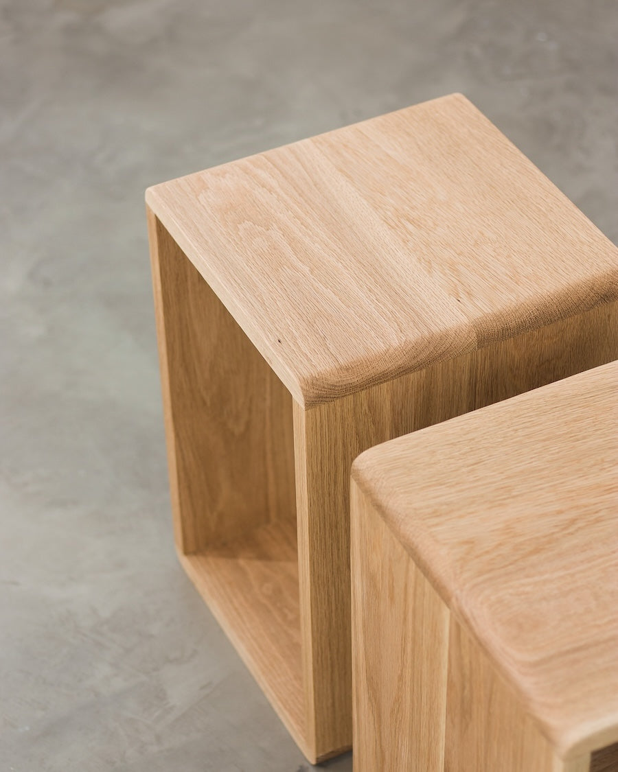 Two wooden stools on a concrete floor