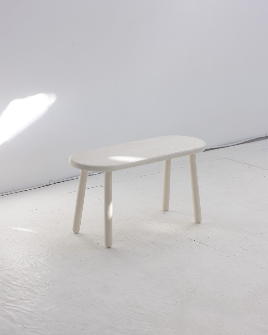 White table on a white floor with a white wall background