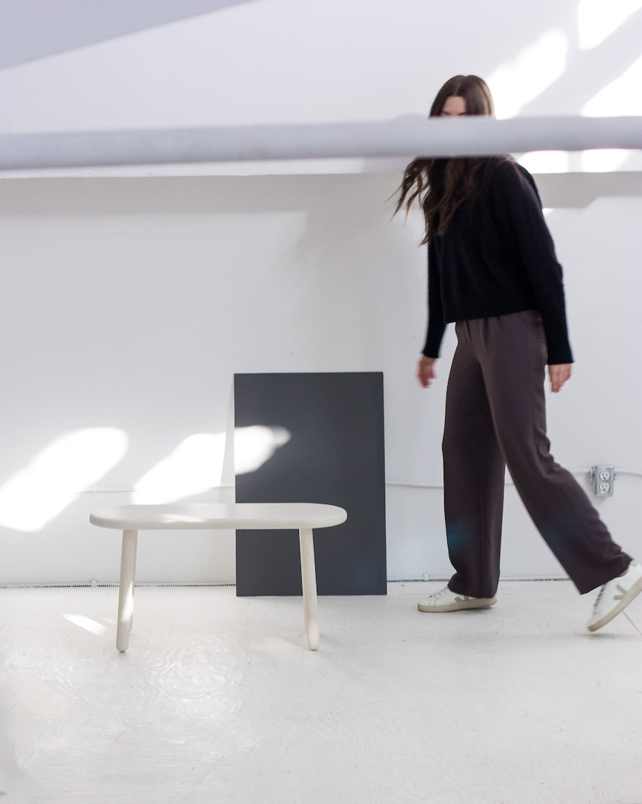 Person standing in a minimalistic room with a white floor and light gray walls.