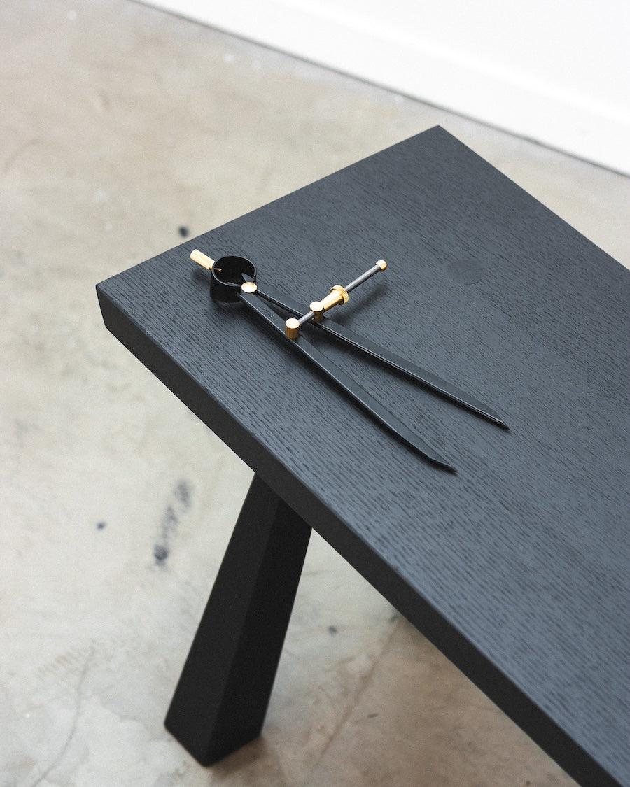 Modern black clock with gold accents on a wooden surface