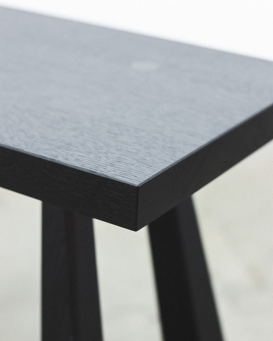Small table with a gray top and black legs on a light background