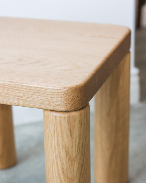 Wooden stool with a light finish on a neutral background