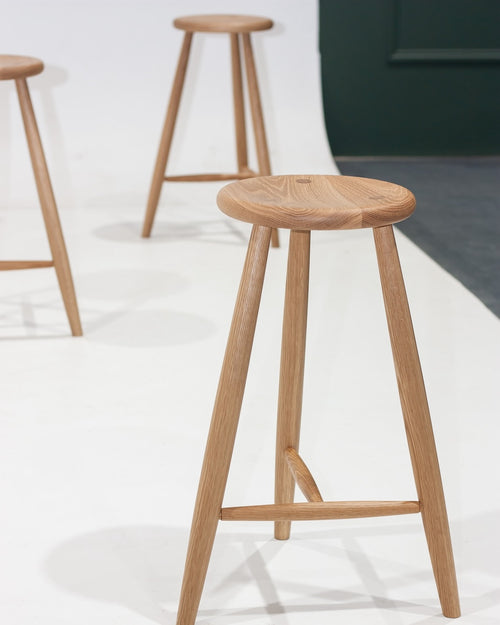 Wooden bar stools on a white floor with a blurred background