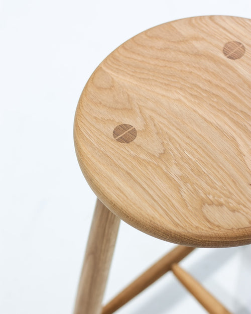 Wooden stool with a light finish on a white background